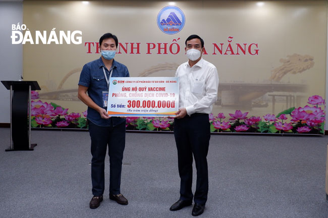 Da Nang People's Committee Chairman Le Trung Chinh (right) receives a symbolic board of donations worth VND 400 million from the Sai Gon - Da Nang Investment Corporation, June 26, 2021. Photo: PHAN CHUNG