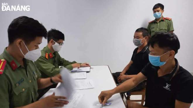 Long and Tuan (both in black) who joined a ring brokering Chinese nationals to unlawfully enter and stay in Viet Nam are kept in custody at the Da Nang facility of the Investigation Security Agency