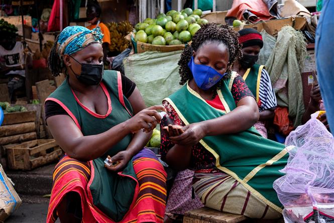 Người dân đeo khẩu trang và sát khuẩn tay phòng dịch COVID-19 tại một khu chợ ở Kampala, Uganda, ngày 23/6/2021. Ảnh: THX/ TTXVN