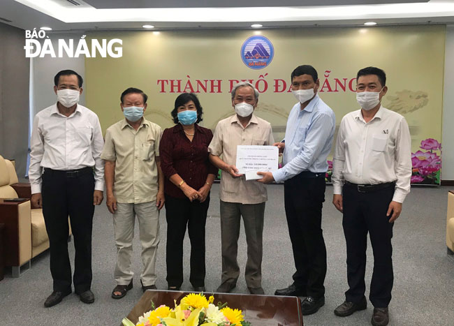 Municipal Peoples Committee Vice Chairman Ho Ky Minh (second, right) receives a symbolic board of donations worth VND 110 million from Thai Phien Club for senior citizens promised to Da Nang’s Vaccine Fund. Photo: NT