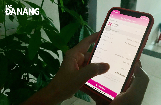 Khách hàng chỉ thanh toán tiền điện qua các kênh chính thống, không thanh toán tiền điện cho người lạ hoặc gửi tiền điện vào tài khoản cá nhân khi chưa xác minh thông tin. Trong ảnh: Người dân sử dụng ví điện tử Momo để thanh toán tiền điện vào tài khoản chính thức của Điện lực Đà Nẵng. Ảnh: K.NINH