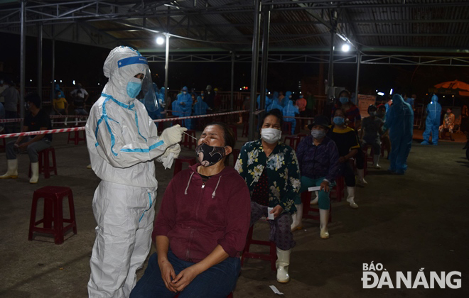  Nasal swab samples are collected for COVID-19 tests from traders, fishermen and others operating at these sites, June 28, 2021. Photo: HOANG HIEP