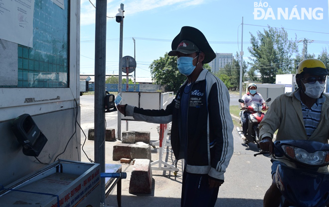 A total of 8,000 people have been provided with access cards to the Tho Quang Fishing Wharf and Seafood Wholesale. They must present their access cards to guards staffing at entrance gates. Photo: HOANG HIEP