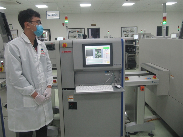 An engineer monitors a control system at the surface-mount technology (SMT) factory in the Đà Nẵng Information Technology Park. The COVID-19 hit factory still maintained production for exporting in the third quarter of 2021. VNS Photo Công Thành 