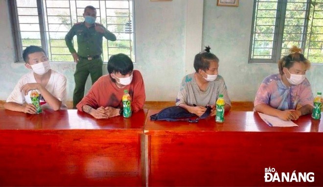 Four illegal Chinese immigrants (sitting) were taken to the Hoa Vang District police station to be questioned. Photo: L.H