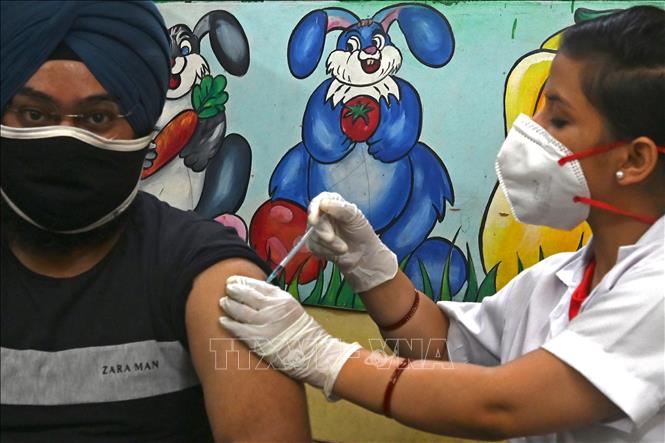 Nhân viên y tế tiêm vaccine Covid-19 cho người dân tại New Delhi, Ấn Độ. Ảnh: AFP/TTXVN