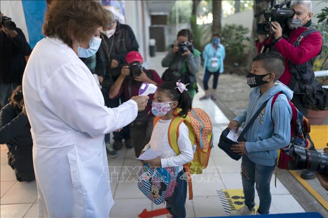 Kiểm tra thân nhiệt của các em học sinh khi trường học mở cửa lại tại Mexico City, Mexico ngày 7-6-2021. Ảnh: THX/TTXVN