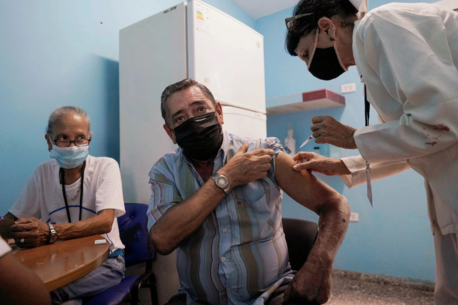 Tháng 5-2021, Cuba bắt đầu sử dụng hai loại vắc-xin ngừa Covid-19 được phát triển trong nước ngay trước khi hoàn thành thử nghiệm lâm sàng giai đoạn 3. TRONG ẢNH: Một người đàn ông Cuba đang được tiêm vắc-xin tại thủ đô Havana ngày 17-6. Ảnh: Reuters