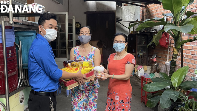 Đại diện chi đoàn khu dân cư 8 (phường Bình Hiên, quận Hải Châu) cùng đại diện Ban Công tác Mặt trận khu dân cư 8 tặng nhu yếu phẩm cho một hộ khó khăn trong khu dân cư vào ngày 9-6.  Ảnh: MAI HIỀN