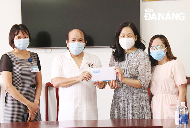 Da Nang Newspaper Deputy Editor-in-Chief  Tran Thi Thu Thuy (second from right) hands over cash support to staff of Hai Chau District Health Center. Photo: THANH TINH