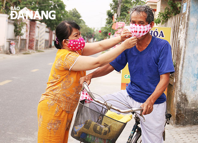  Phụ nữ thôn Cẩm Toại Đông (xã Hòa Phong, huyện Hòa Vang) trao tặng khẩu trang cho người già trong thôn.  Ảnh: THANH TÌNH	