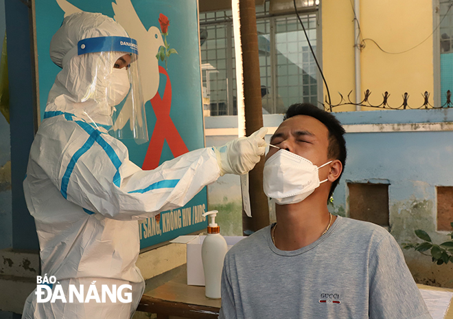 A medical worker takes swab samples of a local resident to test for the virus. Photo: NGOC PHU