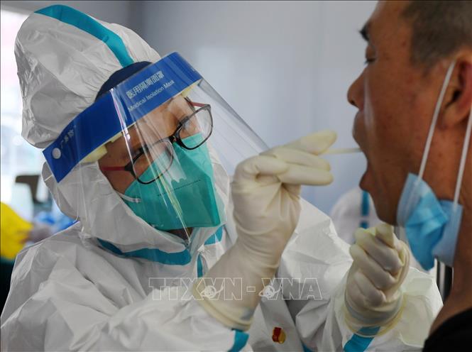 Nhân viên y tế lấy mẫu xét nghiệm COVID-19 tại Bắc Kinh, Trung Quốc. Ảnh: THX/TTXVN