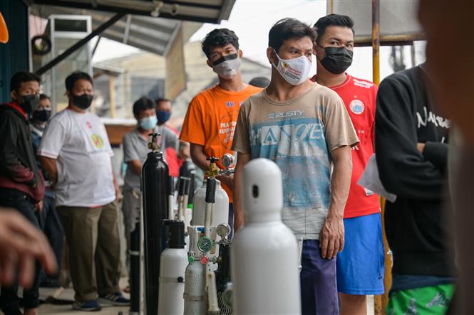 Người dân xếp hàng để nạp bình oxy tại một cửa hàng ở Jakarta, Indonesia, ngày 30/6/2021. Ảnh: AFP/TTXVN