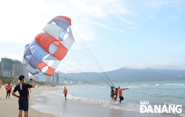 The tourism industry is researching tourism products to match the needs and tastes of visitors when tourism activities are allowed to reopen. In the photo are tourists participating in sports activities on a local beach. (Photo taken in April-2021 by NHAT HA