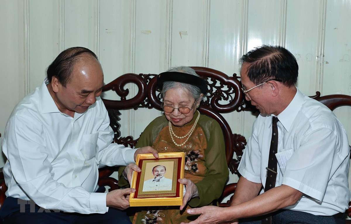 Chủ tịch nước Nguyễn Xuân Phúc đến thăm và tặng quà cho người có công. (Ảnh: Thống Nhất/TTXVN)