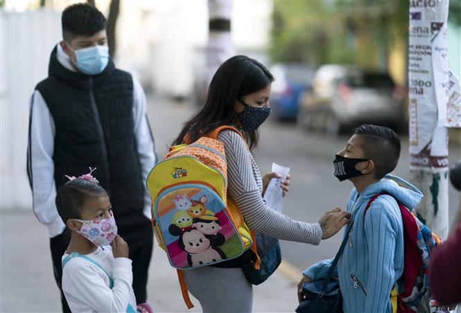 Phụ huynh đưa các em nhỏ đến lớp trở lại sau một thời gian dài thực hiện giãn cách xã hội do dịch Covid-19 tại Mexico City, Mexico ngày 7-6-2021. Ảnh: THX/TTXVN