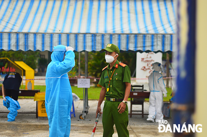  Functional forces on duty at the Vo Chi Cong Senior High School remind candidates to strictly abide by the regulations on COVID-19 prevention and control. Photo: XUAN SON