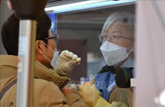 Nhân viên y tế lấy mẫu xét nghiệm COVID-19 cho người dân tại Seoul, Hàn Quốc. Ảnh: AFP/TTXVN