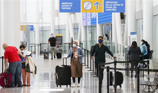 Hành khách đeo khẩu trang phòng lây nhiễm COVID-19 tại sân bay quốc tế ở Ontario, Canada, ngày 5/7/2021. Ảnh: THX/TTXVN