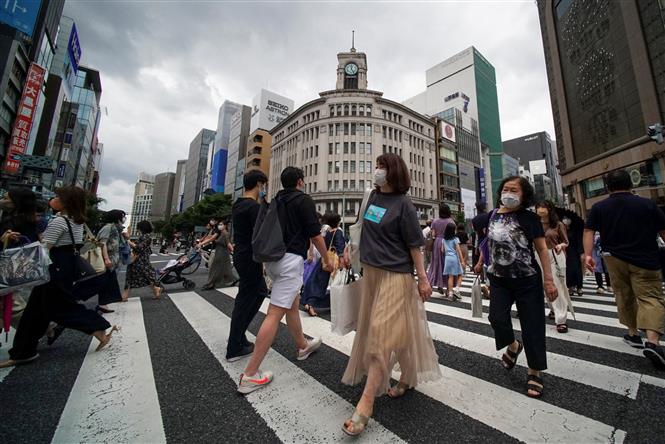 Người dân di chuyển trên đường phố tại Tokyo, Nhật Bản, ngày 27/6/2021. Ảnh: AFP/ TTXVN