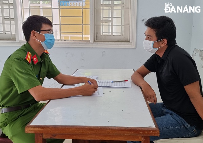 Nguyen Anh Tung (right) is being questioned at the police station. Photo: L.H