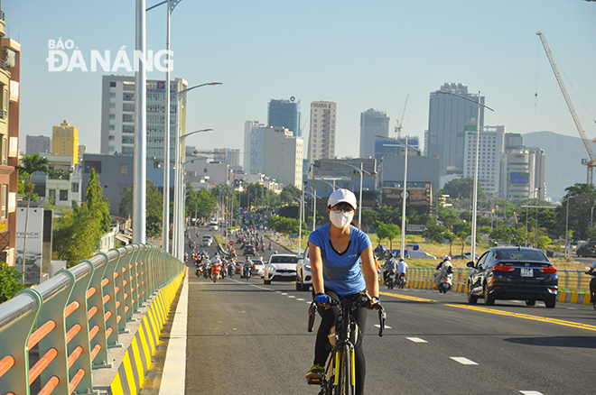 Một người dân đi thể dục bằng xe đạp, tham gia lưu thông trên cầu vượt sáng 14-7. ảnh: THÀNH LÂN