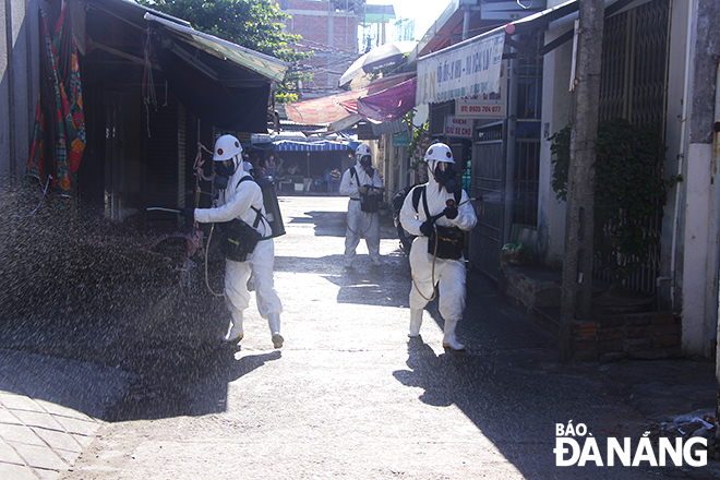 In addition to the use of specialised vehicles, portable sprayers are utilised to disinfect the inside of the Thuan An Market 7 along with houses, alleys, and shops around a hair salon shop at 278 Nguyen Phuoc Nguyen Street whose female owner is infected with COVID-19, July 14, 2021. Photo: Xuan Dung