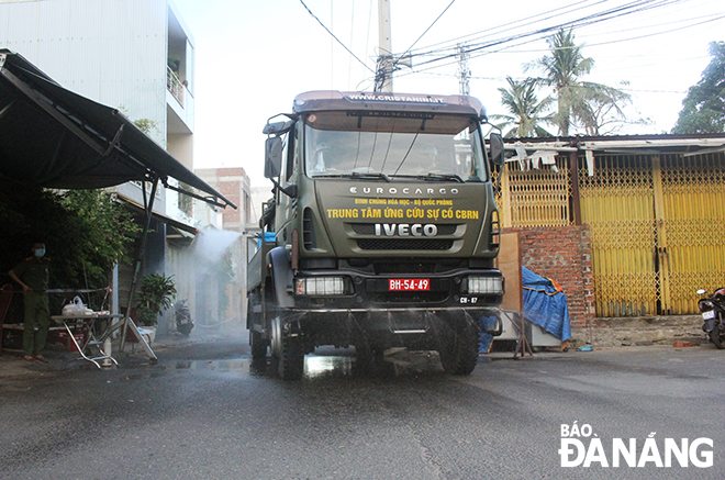  The spraying of disinfectants is conducted in small alleys to ensure COVID-19 prevention and control. Photo: Xuan Dung