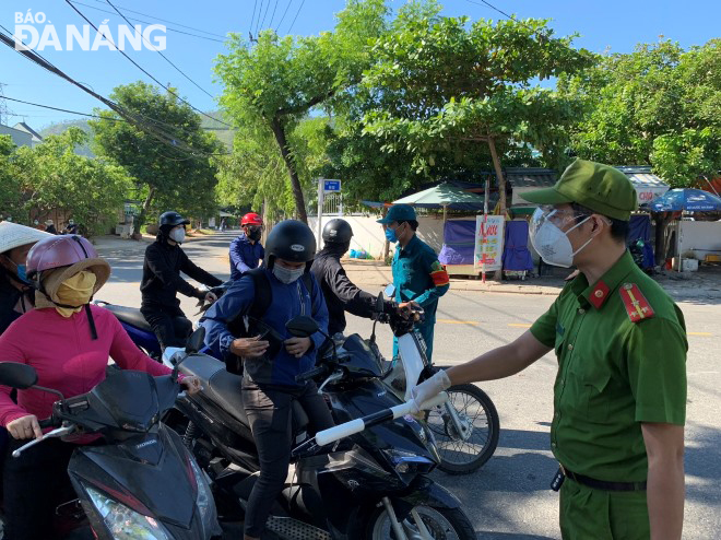 Lực lượng chức năng phường Hòa Khánh Bắc (quận Liên Chiểu) kiểm soát người ra vào khu vực đang thực hiện Chỉ thị số 16/CT-TTg. Ảnh: HOÀNG HIỆP