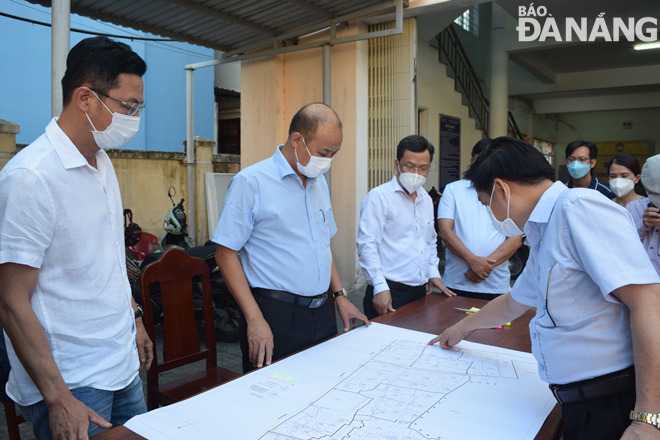Phó Chủ tịch UBND thành phố Lê Quang Nam (thứ 2 từ trái sang) kiểm tra các vị trí chốt chặn, kiểm soát trên sơ đồ ở phường Thạc Gián, quận Thanh Khê. Ảnh: HOÀNG HIỆP