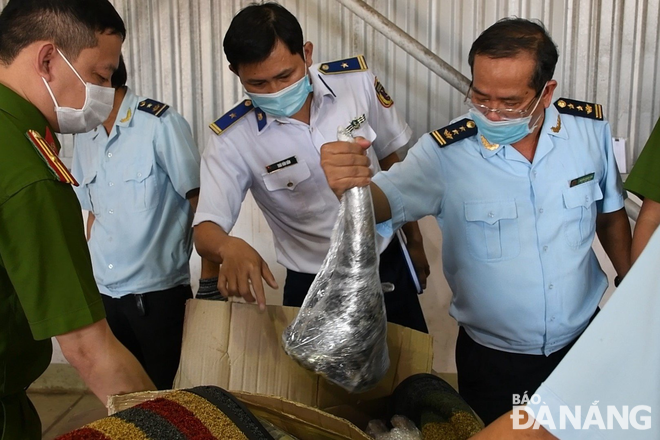 Customs officers work with relevant units to examine the imported shipment of suspected rhino horns and wildlife bones. Photo: M. QUE