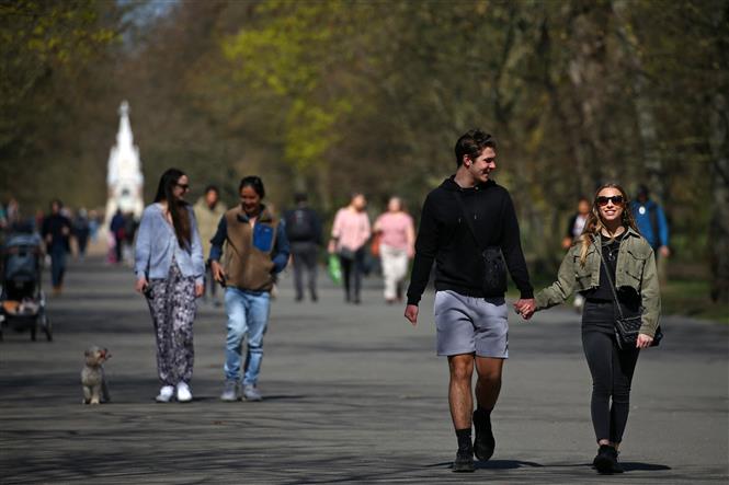 Người dân đi bộ trong một công viên tại London, Anh. Ảnh: AFP/TTXVN