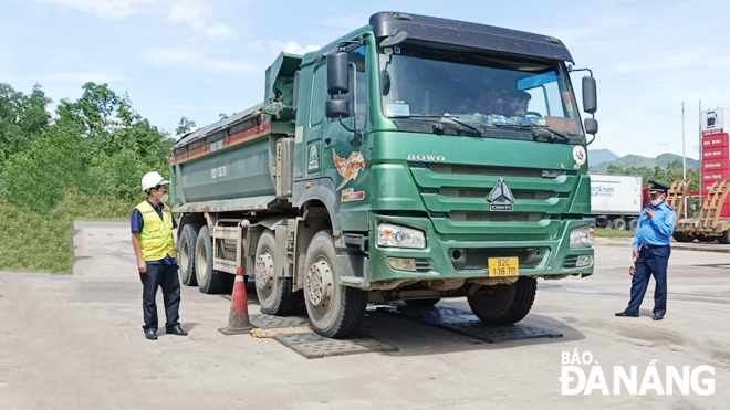 Lực lượng của Cục quản lý đường bộ 3 kiểm tra trọng tải một xe tải trên tuyến đường tránh nam Hải Vân.  (Ảnh chụp tháng 6-2021) Ảnh: THÀNH LÂN	