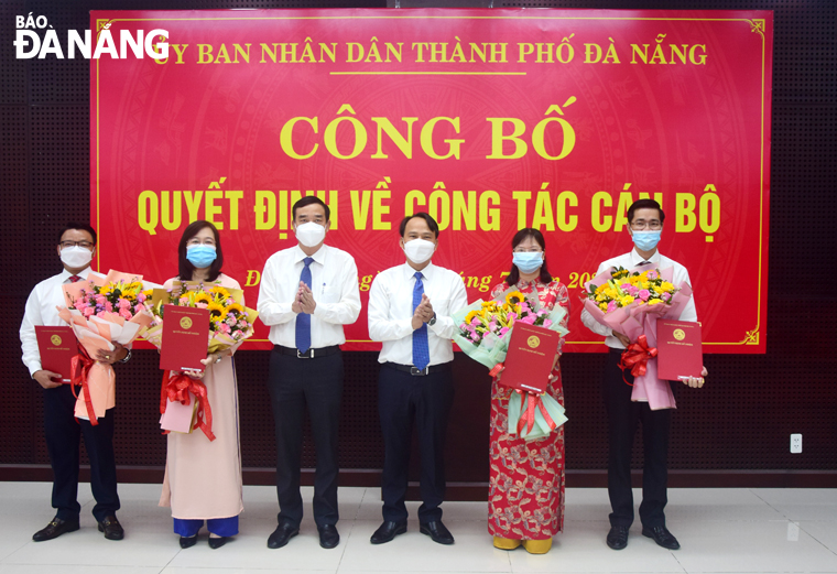 Chủ tịch UBND thành phố Lê Trung Chinh (thứ 3, trái sáng) và Trưởng ban Tổ chức Thành ủy Nguyễn Đình Vĩnh (thứ 3, phải sang) tặng hoa, chúc mừng các cán bộ vừa được bổ nhiệm. Ảnh: T. HUY