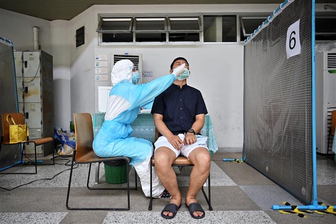 Nhân viên y tế lấy mẫu xét nghiệm Covid-19 cho người dân tại Bangkok, Thái Lan ngày 27-4-2021. Ảnh: AFP/TTXVN