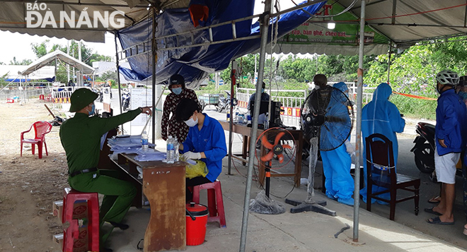 Lực lượng chức năng hướng đẫn, người dân khai báo y tế tại trạm kiểm soát Quốc lộ 1A (gần Trạm CSGT Hòa Phước), huyện Hòa Vang. Ảnh: THÀNH LÂN