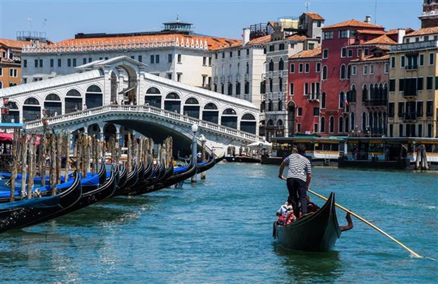 Khách du lịch đi thuyền gondola tại Venice, Italy, ngày 12/6/2020. (Ảnh: AFP/ TTXVN)