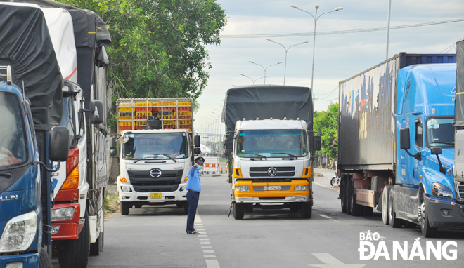 Lực lượng chức năng hướng dẫn xe vào chốt kiểm soát phòng, chống dịch trên quốc lộ 1A, gần Trạm Cảnh sát giao thông cửa ô Hòa Phước, huyện Hòa Vang. (Ảnh chụp ngày 21-7)Ảnh: THÀNH LÂN	