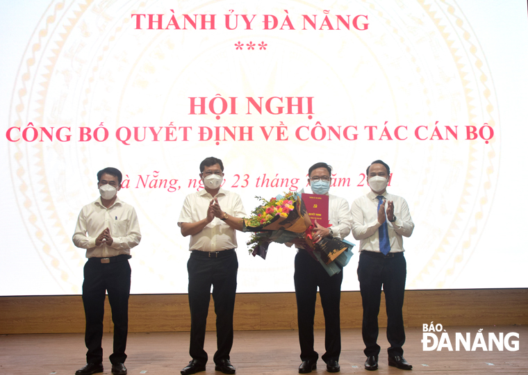 Trưởng ban Tổ chức Thành ủy Nguyễn Đình Vĩnh (bìa phải), Bí thư Quận ủy Liên Chiểu Trần Phước Sơn (thứ 2, trái sang) và Chủ tịch UBND quận Liên Chiểu Nguyễn Đăng Huy (bìa phải) tặng hoa, chúc mừng ông Nguyễn Hữu Thiết (thứ 2, phải sang) tại buổi công bố. Ảnh: T. HUY