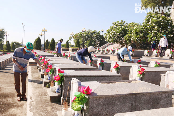 Chính quyền, các hội, đoàn thể xã Hòa Phong (huyện Hòa Vang) dọn vệ sinh, thắp hương tại Nghĩa trang liệt sĩ xã Hòa Phong nhân kỷ niệm Ngày Thương binh - Liệt sĩ 27-7. Ảnh: THANH TÌNH