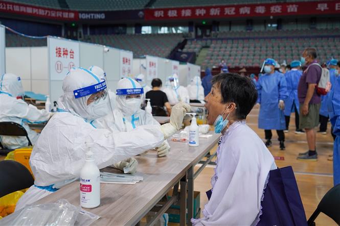 Nhân viên y tế lấy mẫu xét nghiệm COVID-19 cho người dân tại Nam Kinh, tỉnh Giang Tô (Trung Quốc) ngày 22/7/2021. Ảnh: THX/TTXVN
