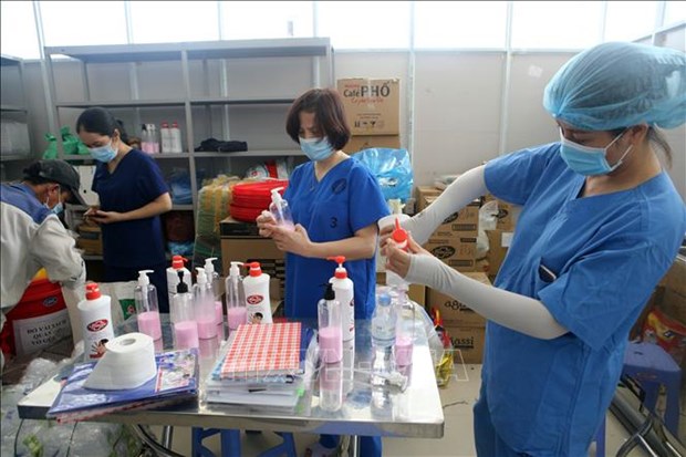 Health workers preparing bottles of hand sanitiser for for patient rooms at a COVID-treatment hospital in Da Nang (Photo: VNA) 