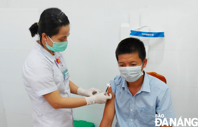 A journalist gets vaccinated for COVID-19. Photo: PHAN CHUNG