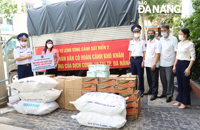 Colonel Le Huy Sinh, Political Commissar of the Coast Guard Region 2 Command (left) hands over gifts in-kind to the Da Nang Party Committees Mass Mobilization Commission to go to help local struggling families in COVID-19 crisis. PHOTO: NAM TRUNG