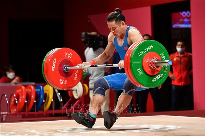 Đô cử Thạch Kim Tuấn thi đấu ở hạng cân 61 kg nam môn cử tạ tại Oympic Tokyo 2020 ngày 25/7/2021. Ảnh: AFP/TTXVN