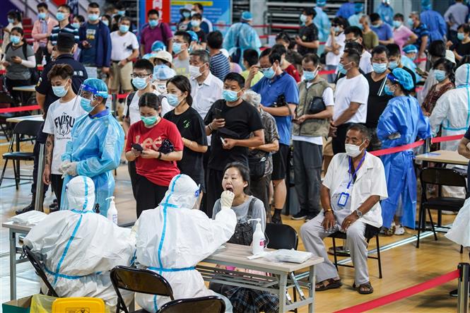 Nhân viên y tế lấy mẫu xét nghiệm COVID-19 cho người dân tại Nam Kinh, tỉnh Giang Tô, Trung Quốc, ngày 22/7/2021. Ảnh: THX/ TTXVN