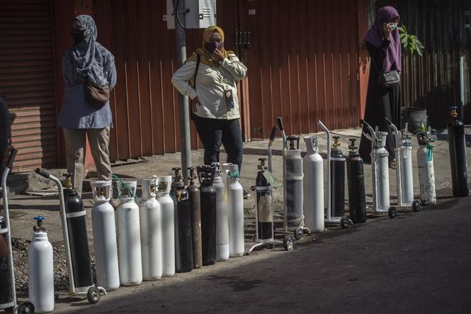 Người dân xếp hàng chờ bơm oxy y tế phục vụ điều trị cho bệnh nhân COVID-19 tại thành phố Surabaya, Đông Java, Indonesia, ngày 15/7/2021. Ảnh: AFP/TTXVN