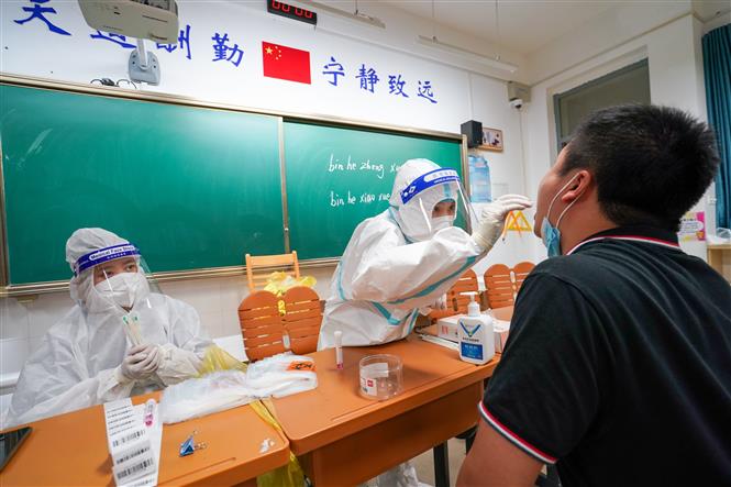 Nhân viên y tế lấy mẫu xét nghiệm Covid-19 tại Nam Kinh, Trung Quốc, ngày 25-7-2021. Ảnh: THX/TTXVN