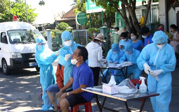Lực lượng Y tế lấy mẫu test nhanh cho người dân trong khu vực nhà bệnh nhân sinh sống. (Ảnh: Phước Tuệ/TTXVN)